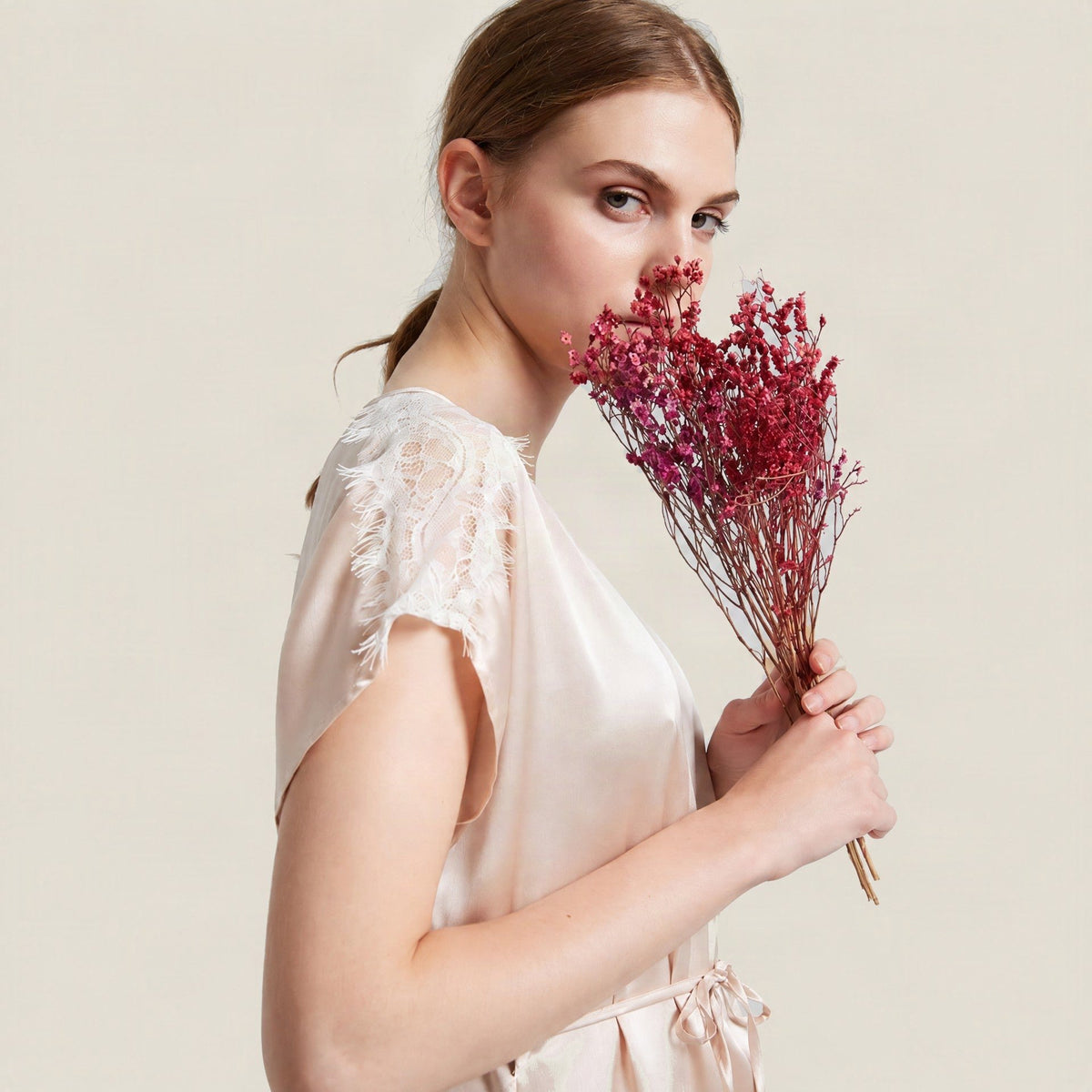 Blush pink 19 momme mulberry silk nightgown with white lace cap sleeves, side view on a model
