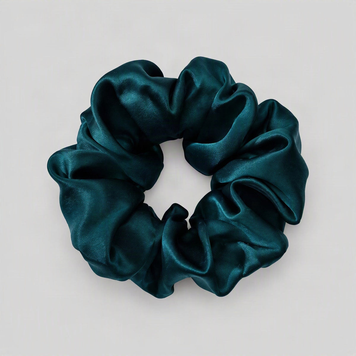 SuuSilk mulberry silk scrunchie in soft pastel hue, gently gathered on a marble surface with natural light