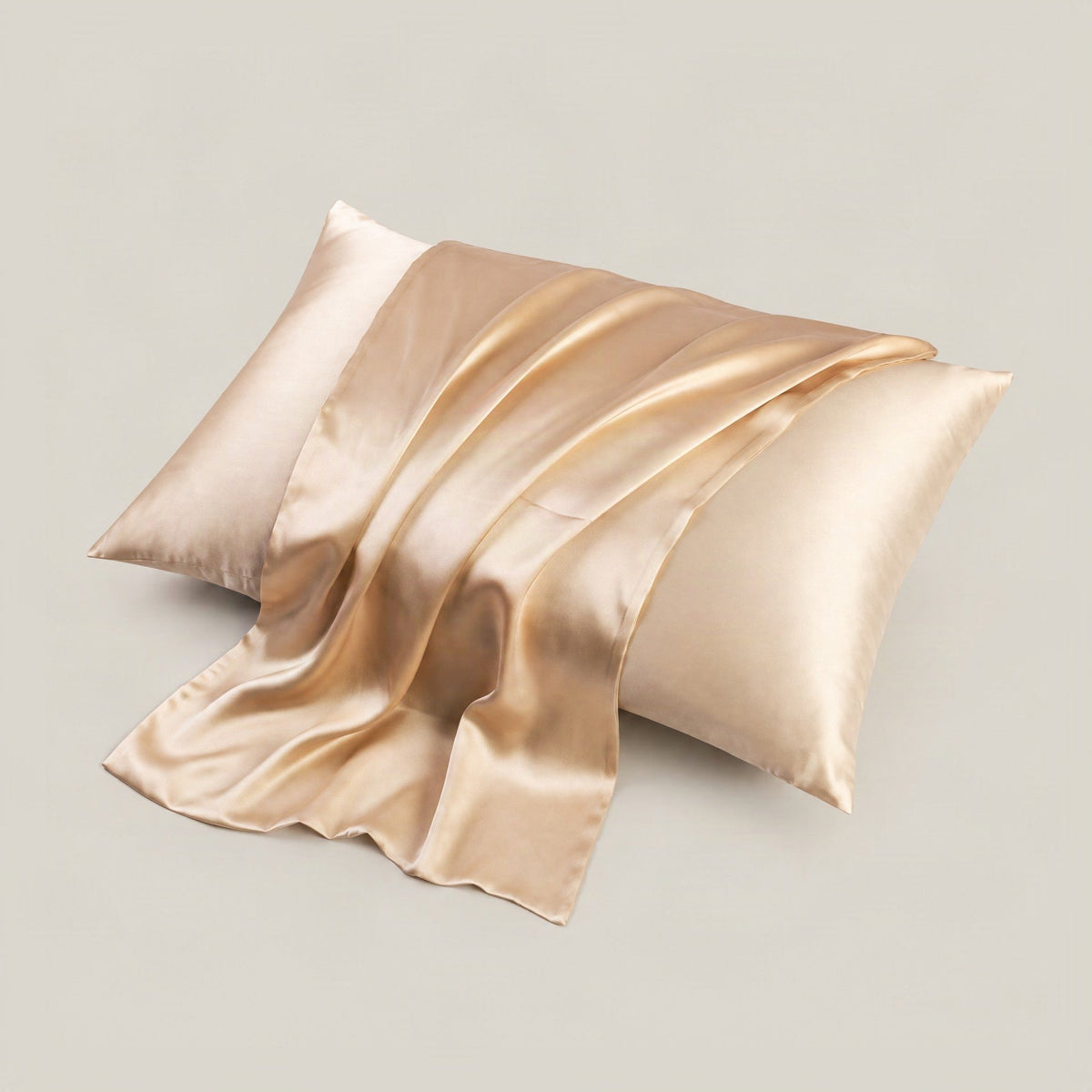 SuuSilk 19 Momme mulberry silk pillowcase in soft blush tone draped on a styled bed with neutral linen sheets