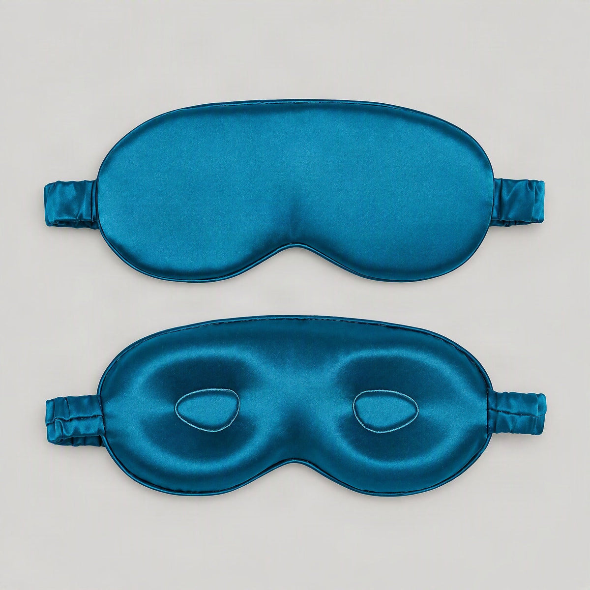 SuuSilk 19 Momme 3D Contoured Mulberry Silk Sleep Eye Mask in soft ivory, displayed on a bedside table