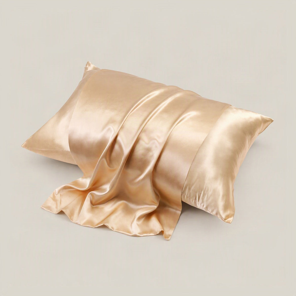 SuuSilk 22 Momme glossy mulberry silk pillowcase in blush pink, displayed on a styled bed with hidden zipper detail visible.