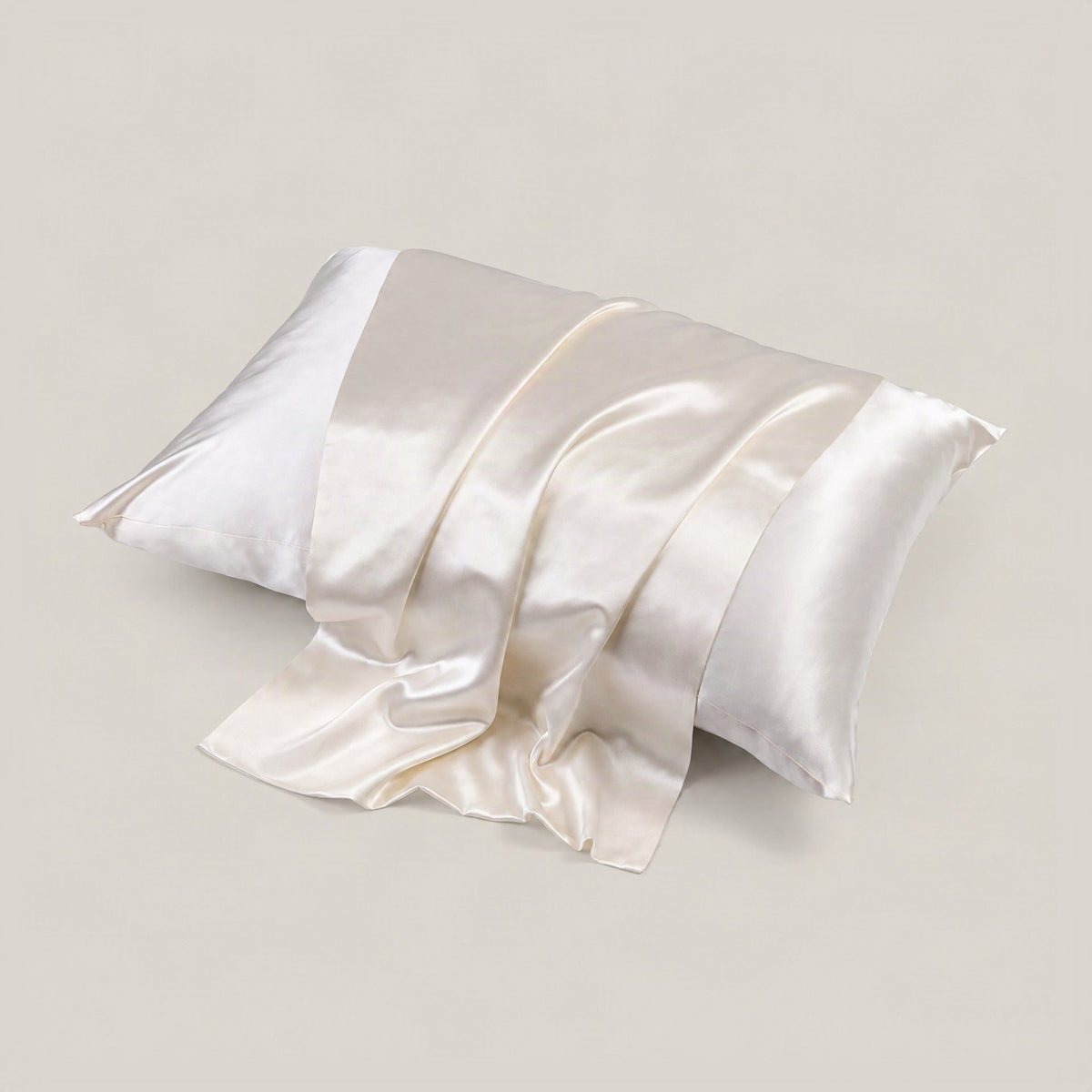 SuuSilk glossy double-sided silk pillowcase in blush pink draped on a styled bed, highlighting its smooth 22 momme mulberry s