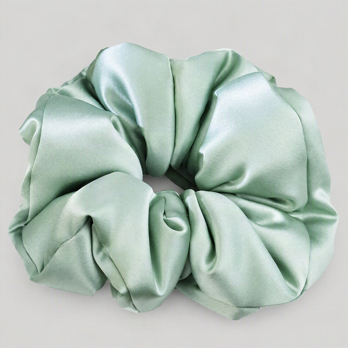Woman wearing a champagne-colored 30 Momme mulberry silk scrunchie, showcasing its gentle hold on her hair