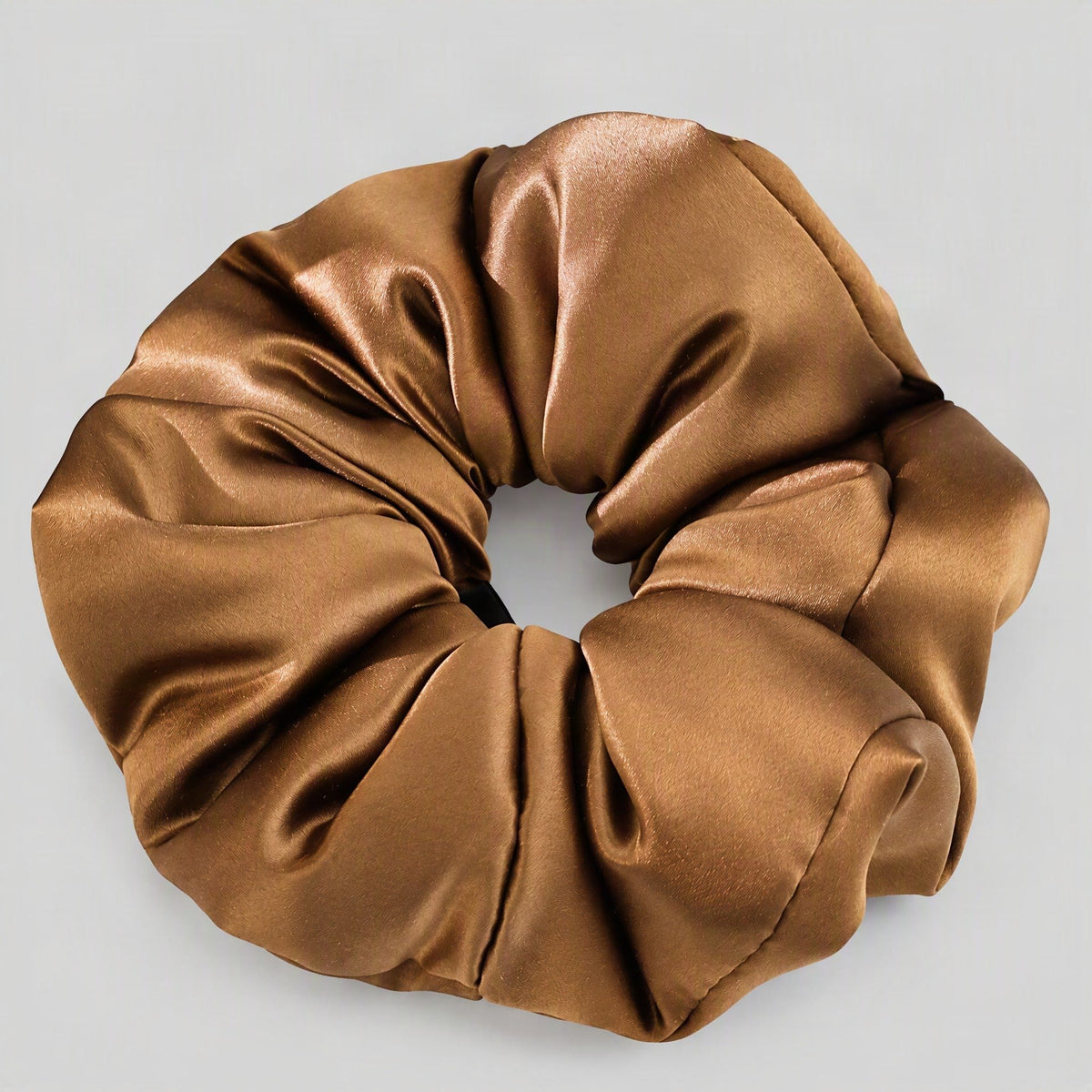 SuuSilk 30 Momme mulberry silk scrunchie in soft champagne, styled on a marble vanity with warm natural lighting