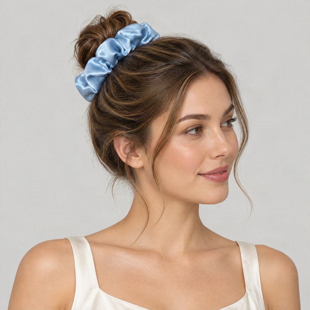 SuuSilk mulberry silk scrunchie in soft pastel hue, gently wrapped around a wrist in natural light