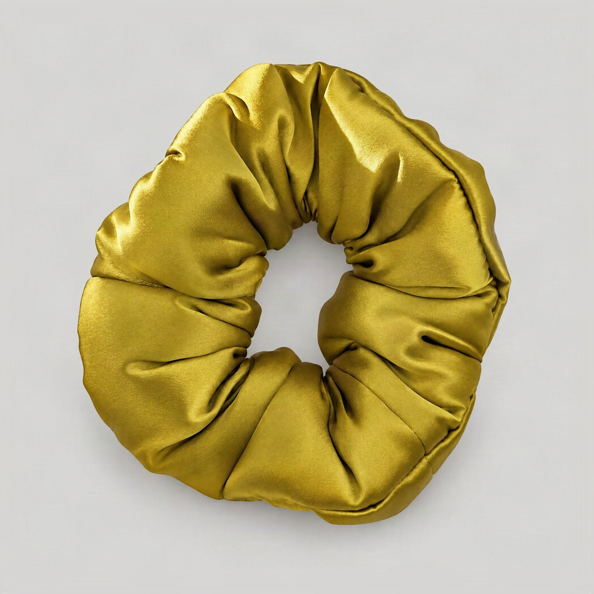 Close-up detail of SuuSilk 30 Momme Mulberry Silk Scrunchie, revealing its soft padded body and gentle sheen in a minimalist 