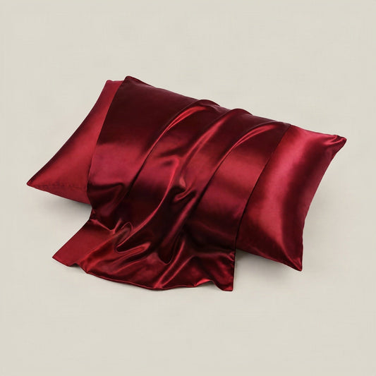 SuuSilk 22 Momme glossy mulberry silk envelope pillowcase in soft pastel tones, styled on a bed with hidden closure visible