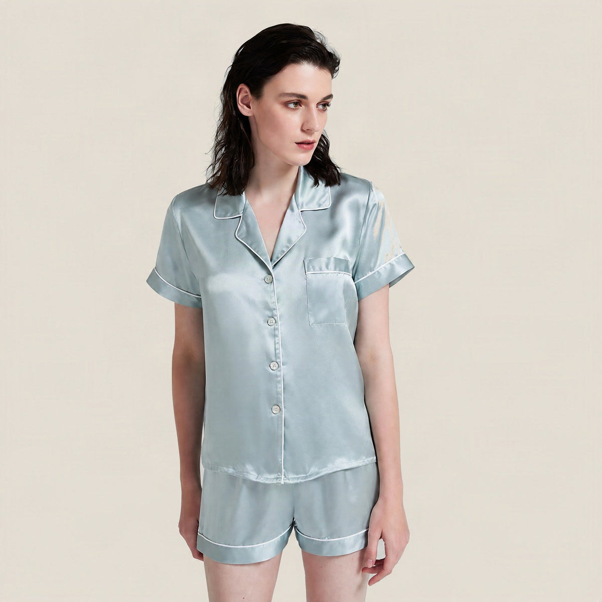 Sage blue 19 momme mulberry silk short-sleeve pajama set with white piping and shorts, worn by a model