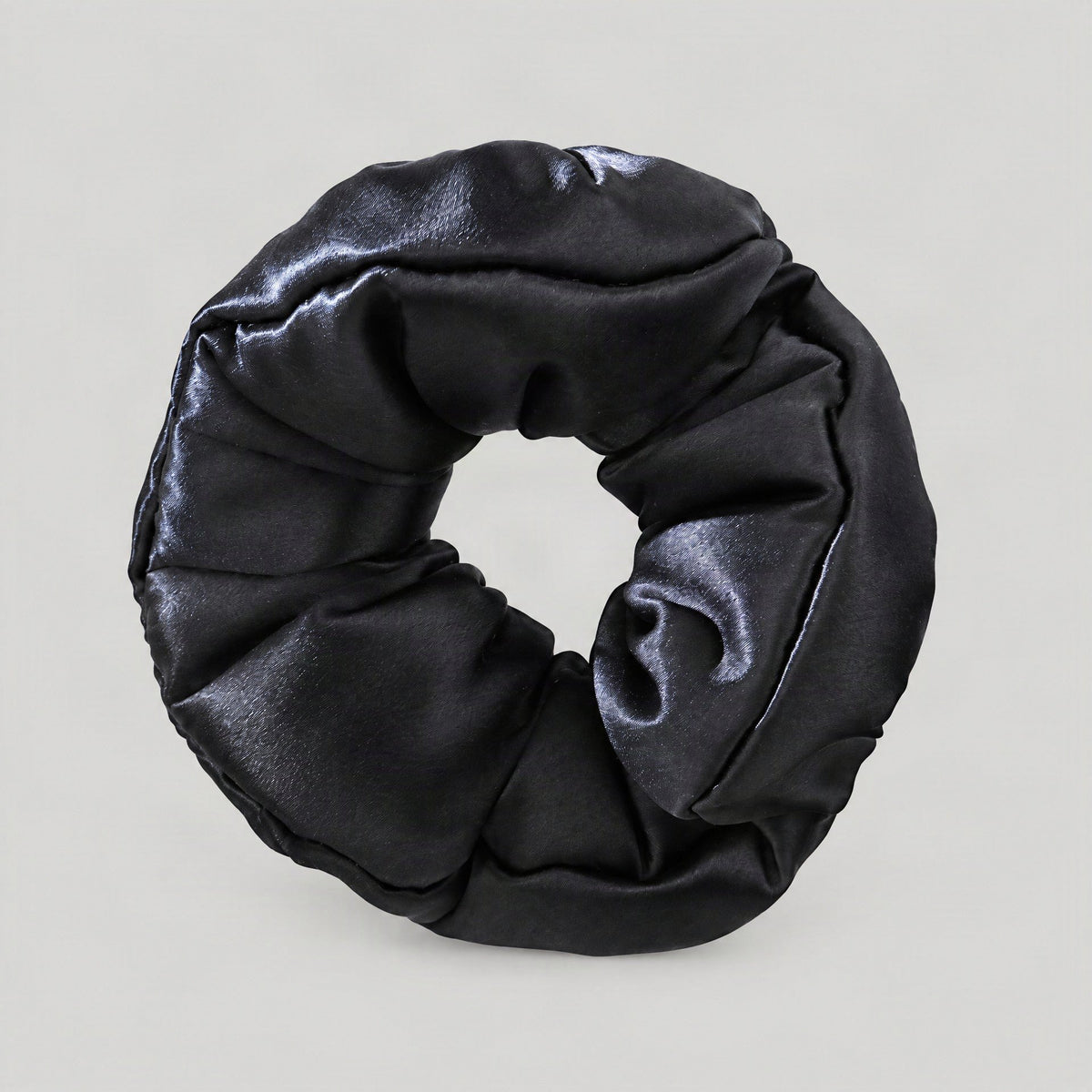 SuuSilk 30 Momme padded mulberry silk scrunchie in soft blush pink, styled on a marble surface with delicate dried florals ne