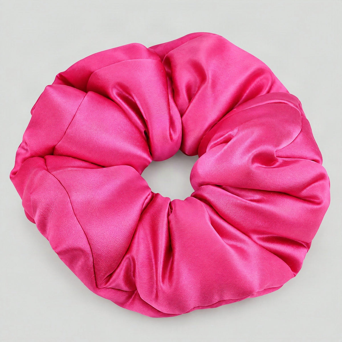 SuuSilk 30 Momme mulberry silk padded scrunchie in soft blush tone, styled on a marble surface for everyday hair care