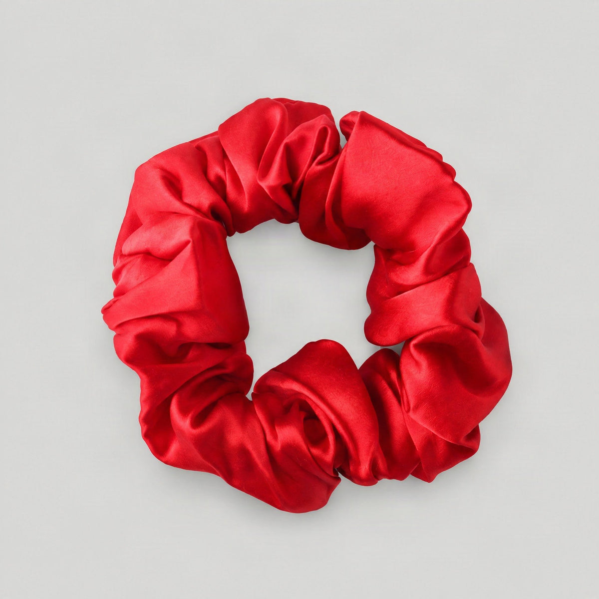 SuuSilk 16 Momme ruffled mulberry silk scrunchie in soft blush pink, styled on a marble surface for everyday hair care