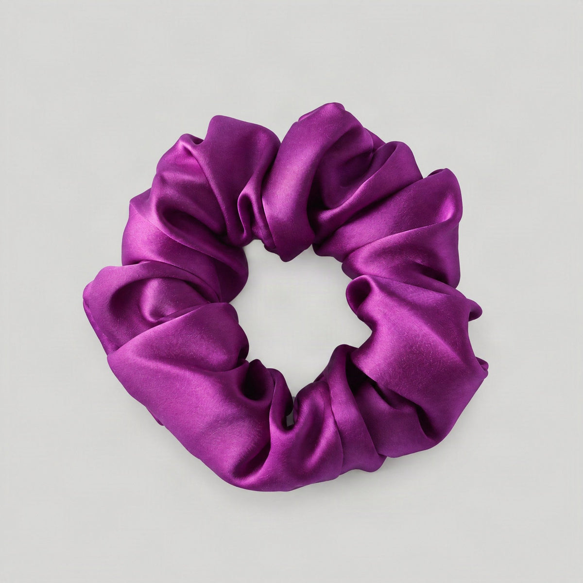 SuuSilk 16 Momme ruffled mulberry silk scrunchie in soft blush pink, styled on a marble surface for everyday hair care.