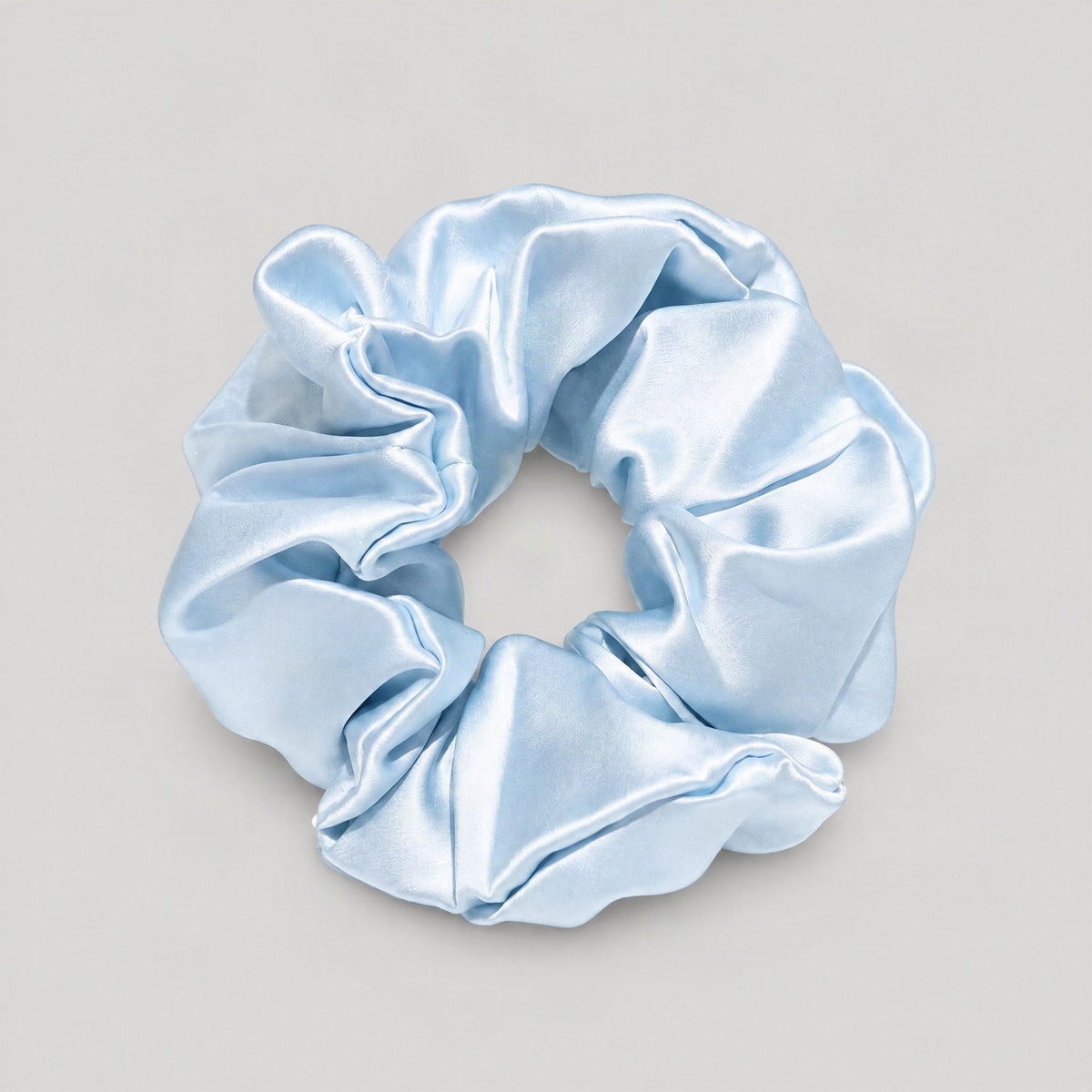 Woman wearing a champagne-colored 30 momme mulberry silk scrunchie, showcasing its gentle hold on hair for everyday wear.