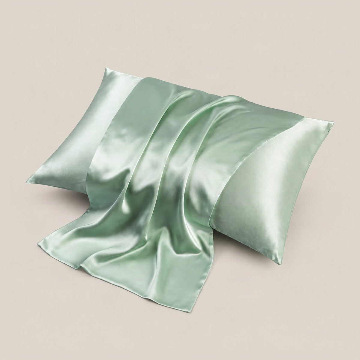 Sleepwear product in dusty rose silk laid on neutral linen bedding