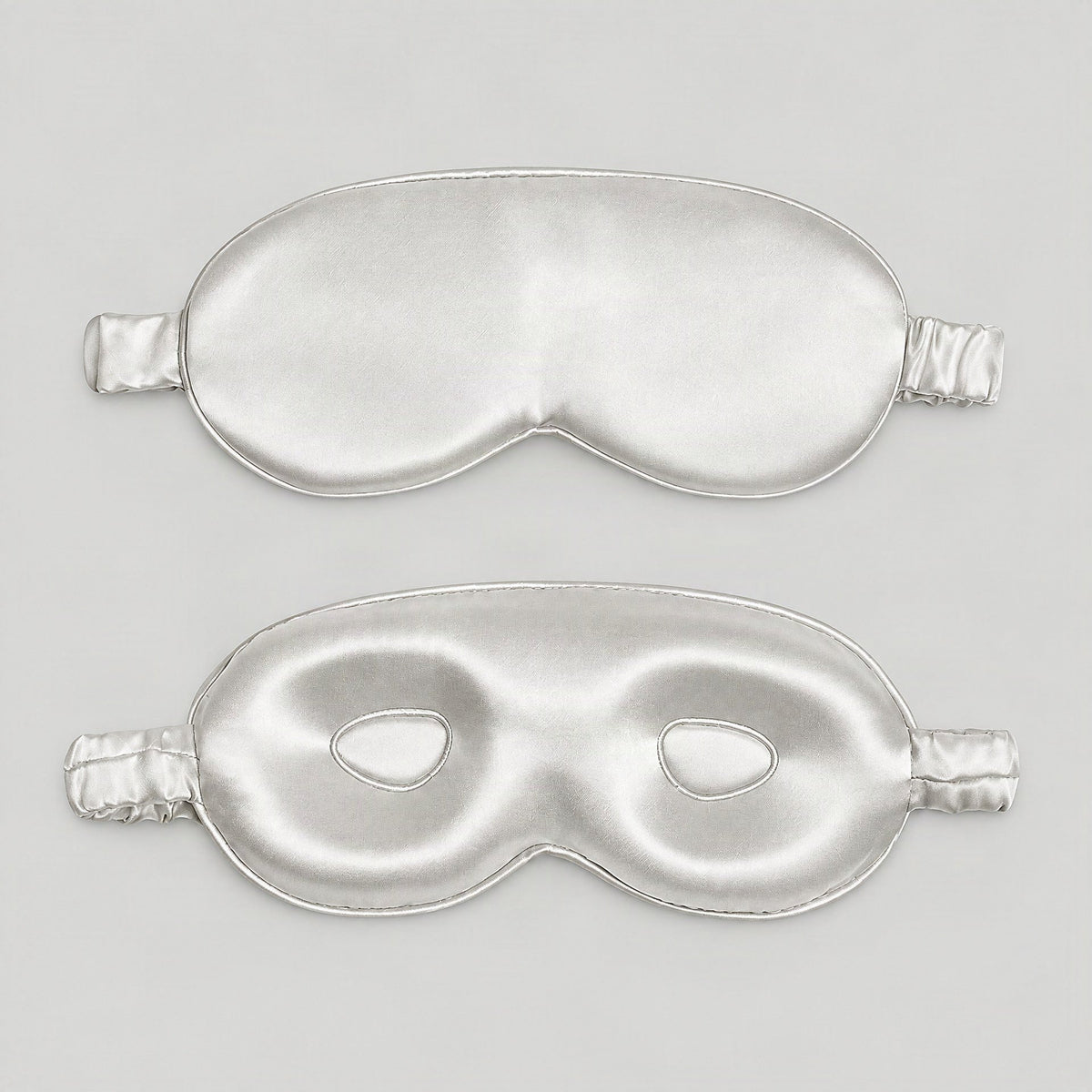 SuuSilk 19 Momme mulberry silk sleep eye mask displayed on a nightstand beside a warm lamp