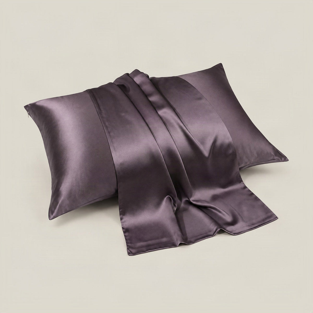 SuuSilk 30 Momme mulberry silk pillowcase in soft blush pink, shown draped on a bed with hidden zipper detail visible