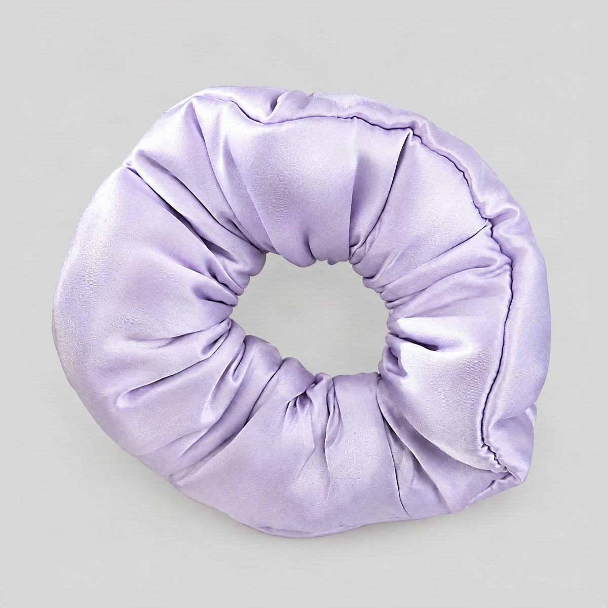 SuuSilk 30 Momme mulberry silk scrunchie in soft blush, gently scrunched on a marble surface beside a hairbrush