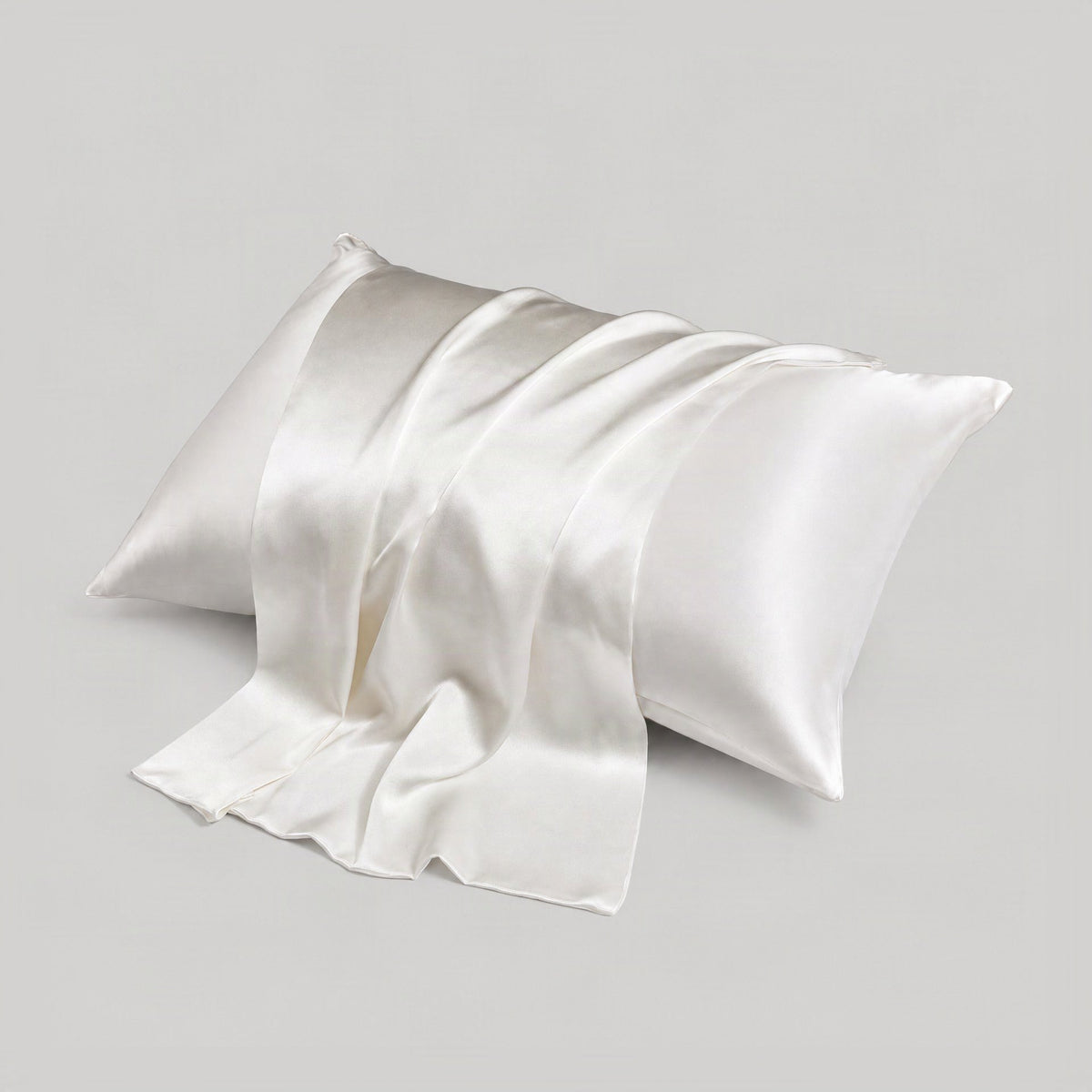 White SuuSilk 16 Momme mulberry silk pillowcase with hidden zipper draped elegantly on a styled bed setting